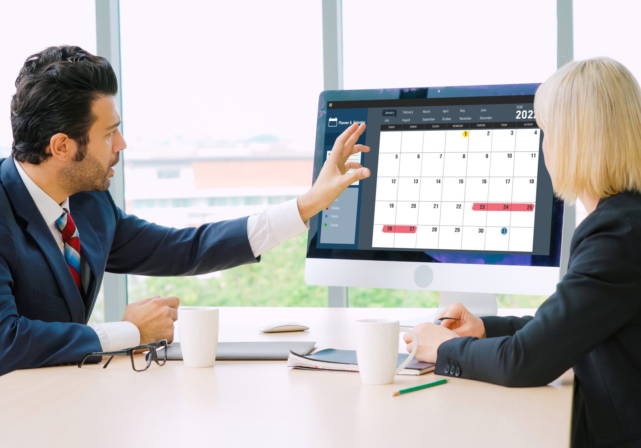 Two professionals reviewing a real estate market dashboard on a computer screen.