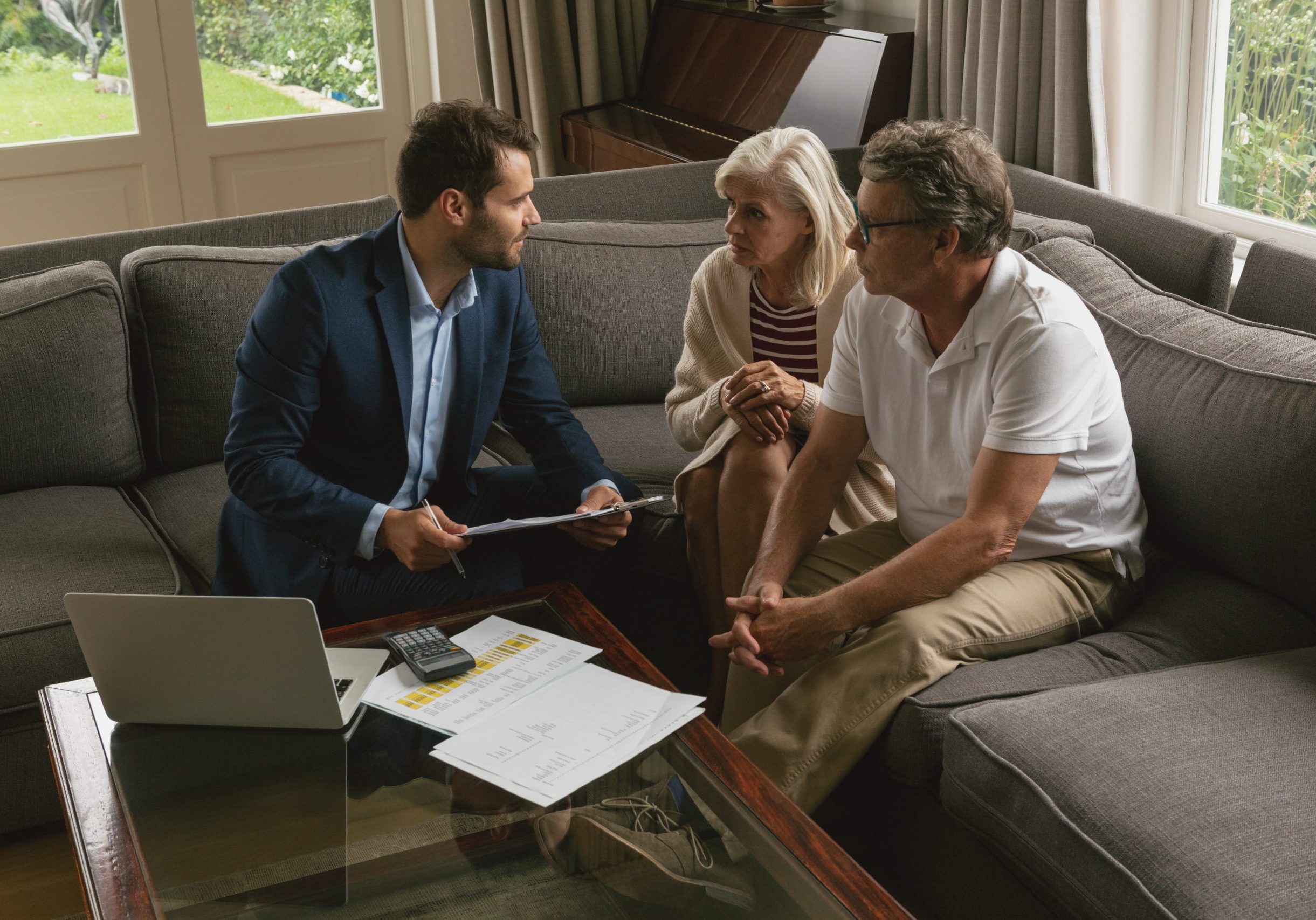 Real estate professional sitting on a sofa discussing options with a couple.